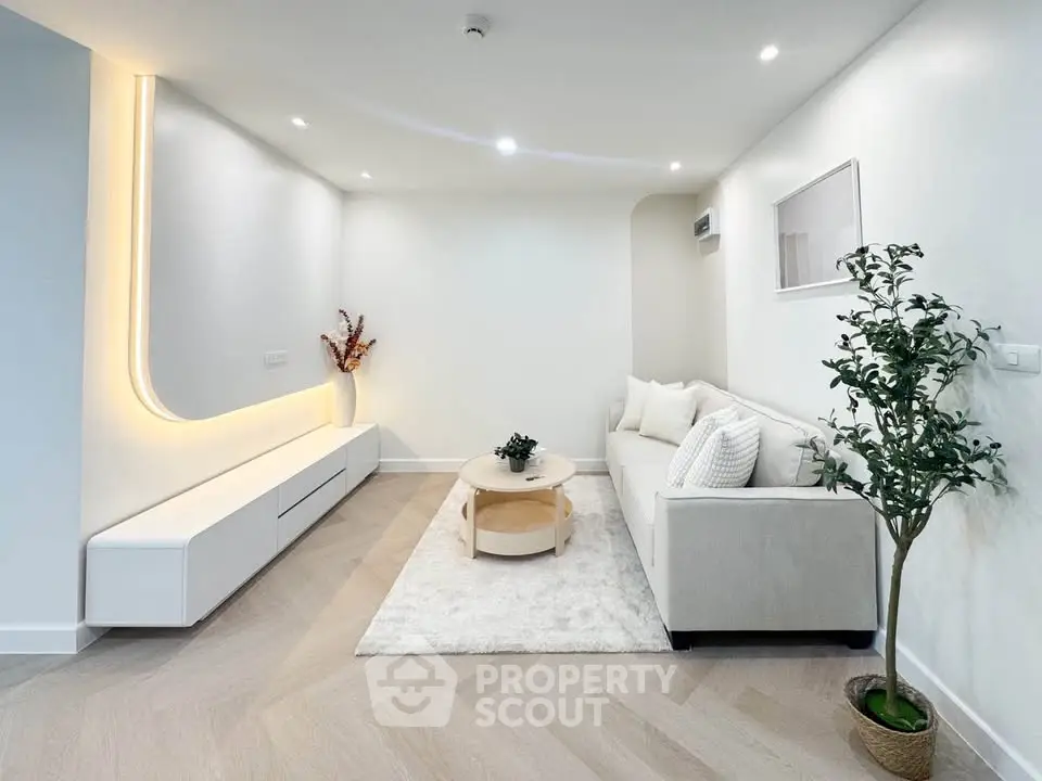 Modern living room with sleek design, featuring a cozy sofa, stylish lighting, and elegant decor.
