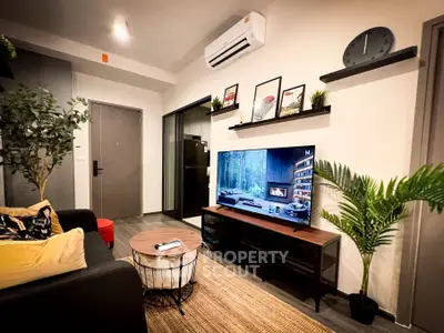 Modern living room with stylish decor and large TV, perfect for relaxation and entertainment.