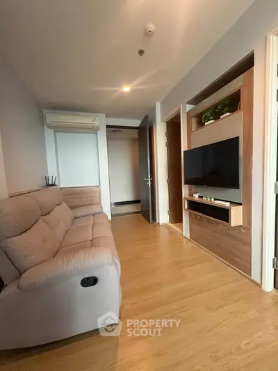 Modern living room with cozy sofa and wall-mounted TV in stylish apartment.