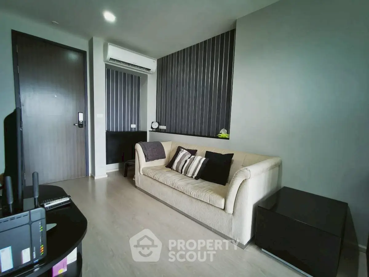 Modern living room with sleek design and neutral tones, featuring a comfortable sofa and stylish decor.