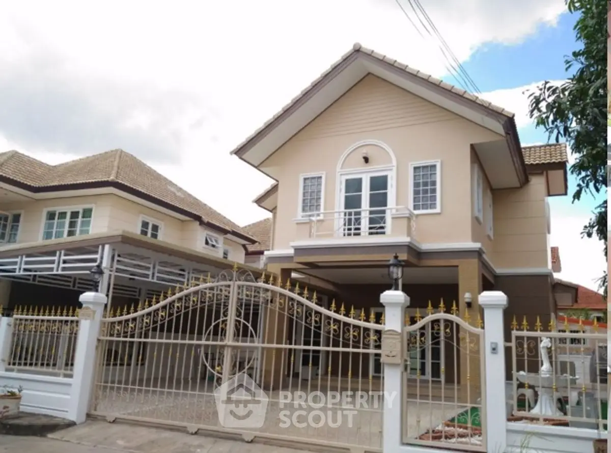 Charming two-story house with gated entrance and elegant architecture.