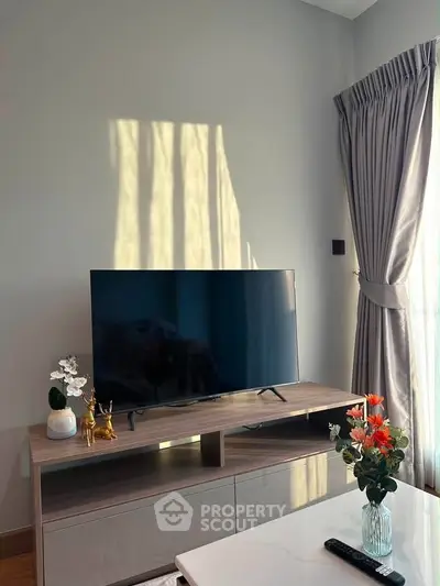 Modern living room with stylish TV stand and elegant curtains, perfect for cozy relaxation.