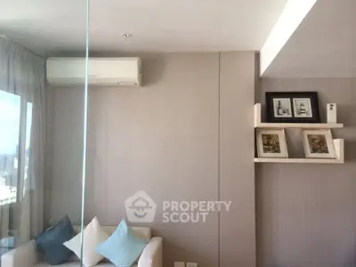 Modern living room with air conditioning and stylish shelving, featuring cozy seating and decorative pillows.