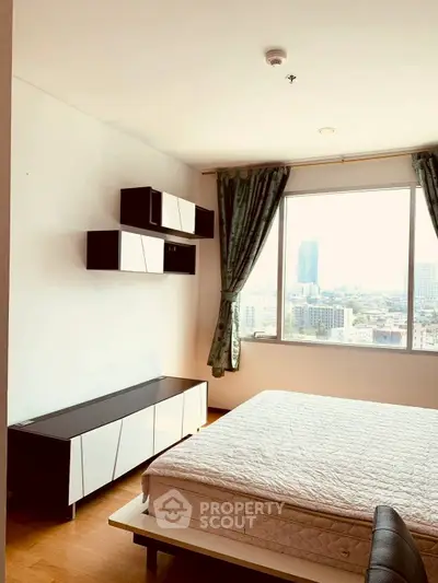 Bright and modern bedroom with city view, featuring stylish furniture and large window.