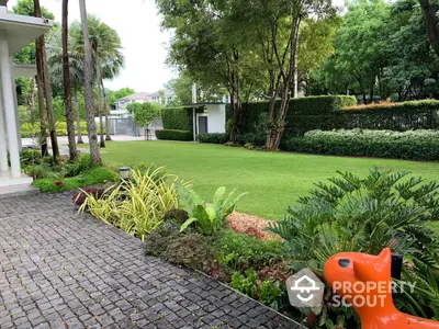 Lush green garden with manicured lawn and tropical landscaping, perfect for serene outdoor living and entertaining in a luxury property.