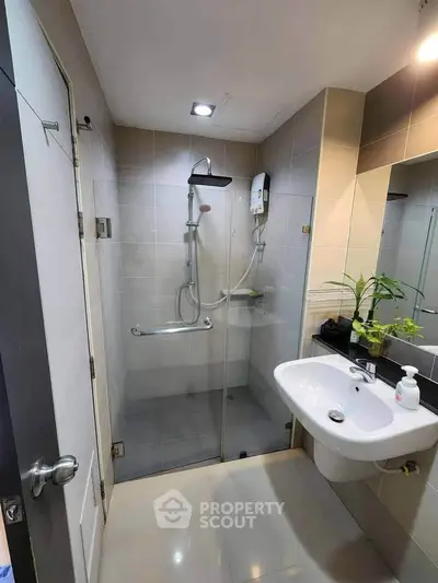 Modern bathroom with glass shower enclosure and sleek fixtures