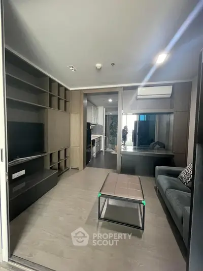 Modern living room with sleek furniture and open kitchen layout in a stylish apartment.