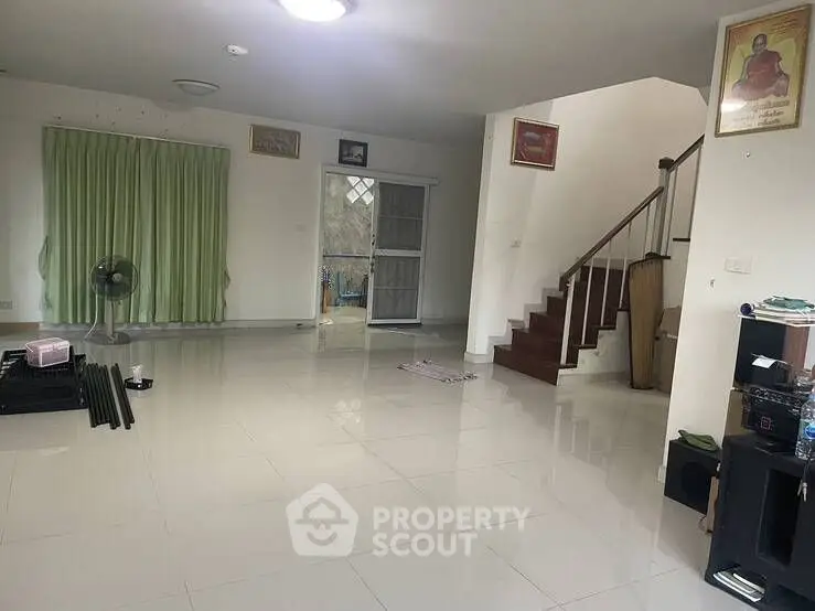 Spacious living room with tiled floor and staircase in modern home