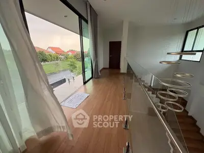 Spacious modern hallway with wooden flooring and large windows offering scenic views.