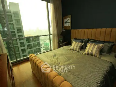 Luxurious bedroom with floor-to-ceiling windows offering stunning city views.