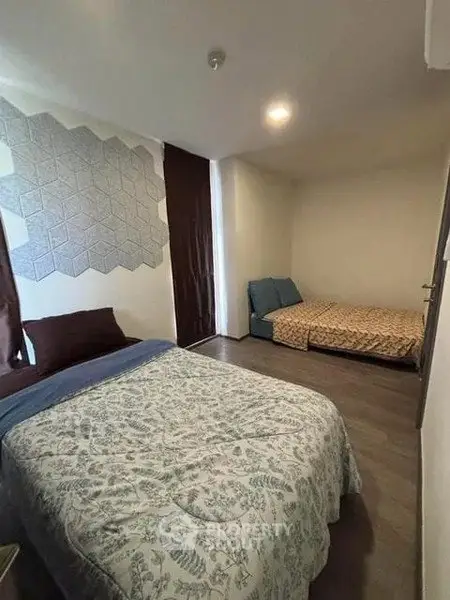 Cozy bedroom with two beds and modern decor, perfect for relaxation.
