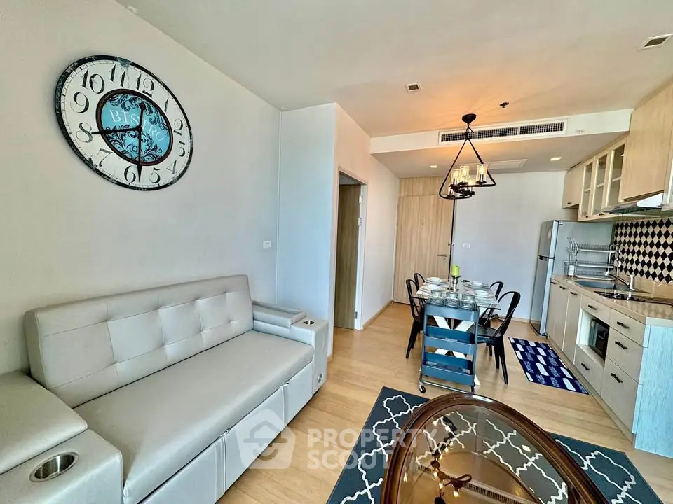 Modern open-layout living room and kitchen with stylish decor and dining area.