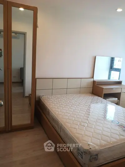 Spacious bedroom with modern wooden furniture and large mirror