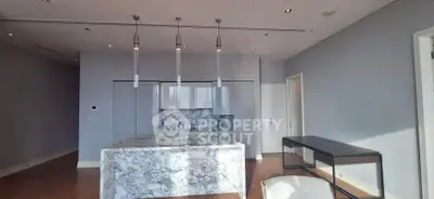 Luxurious kitchen with marble island and modern lighting in upscale apartment