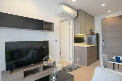Modern living room with sleek furniture and open kitchen layout in a stylish apartment.