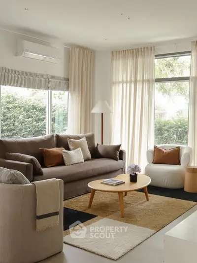 Elegant living room with modern furniture and large windows offering natural light.