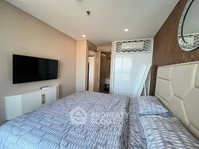 Modern bedroom with stylish decor and wall-mounted TV in a high-rise apartment.