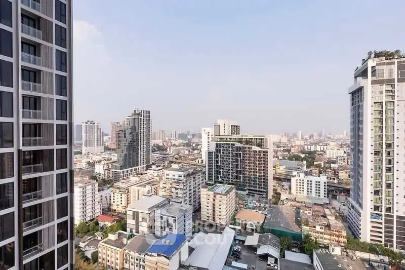 Stunning cityscape view from high-rise apartment balcony in urban setting.