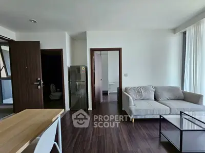 Modern living room with sleek furniture and open layout, featuring a cozy sofa and stylish dining area.
