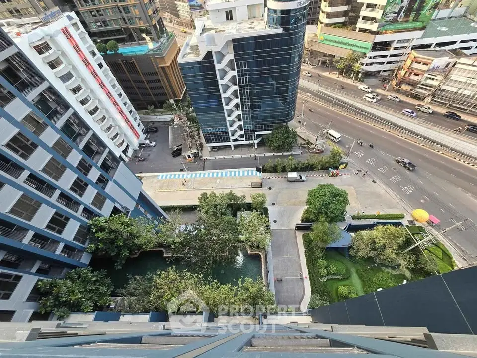 Stunning aerial view of modern urban buildings with lush greenery and busy streets below.