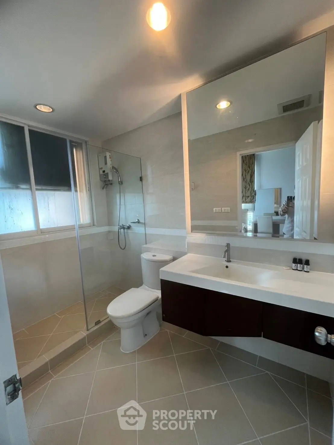 Modern bathroom with glass shower and sleek vanity in a stylish home.