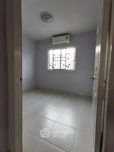 Spacious empty room with air conditioning and tiled floor, ready for customization.