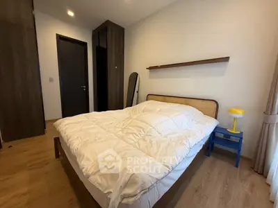 Cozy bedroom with modern decor and wooden flooring, featuring a comfortable bed and stylish lighting.