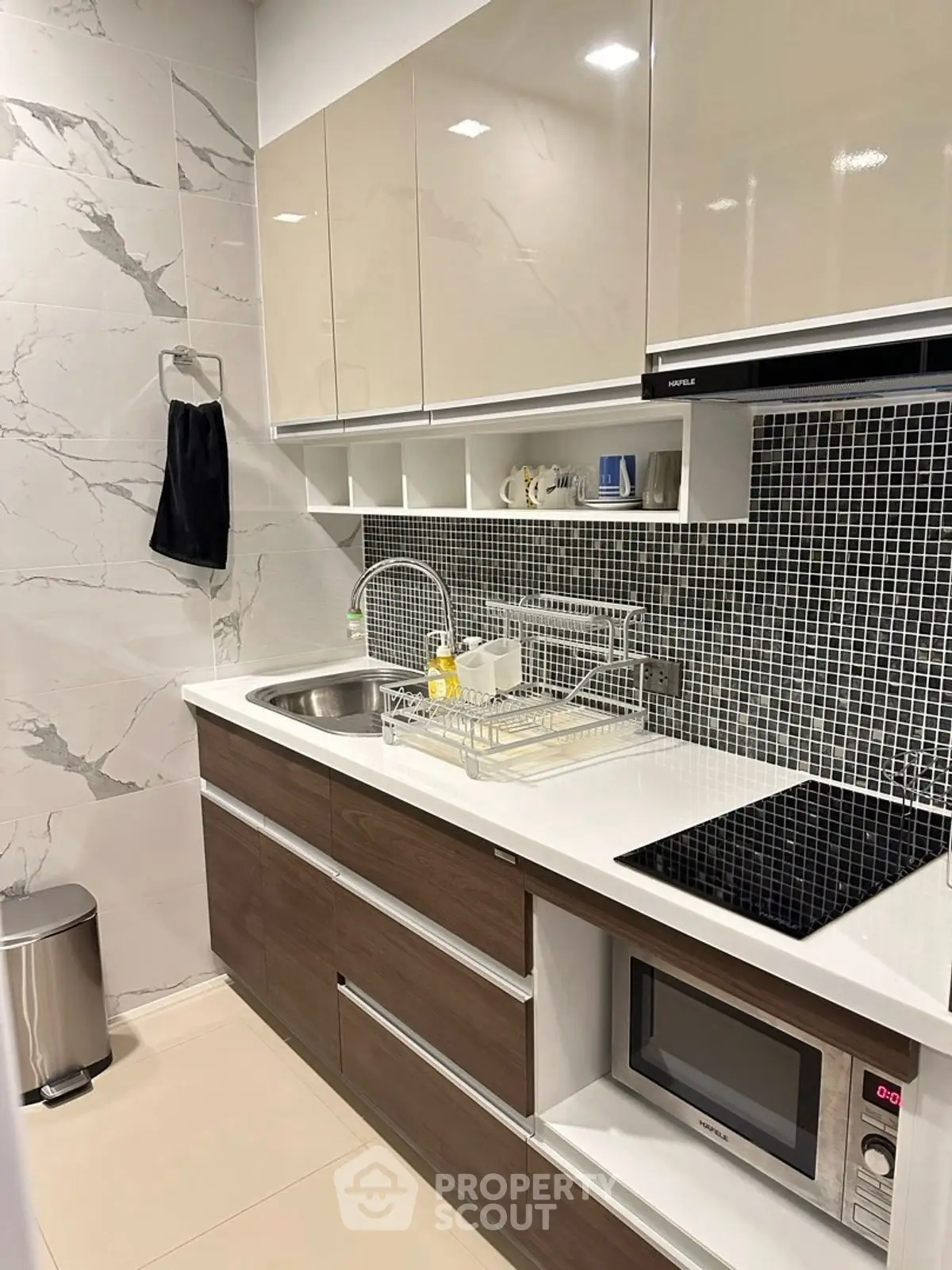 Modern kitchen with sleek cabinetry and built-in appliances, featuring a stylish backsplash.