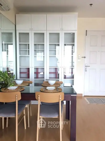 Modern dining area with glass table and wooden chairs in a bright apartment