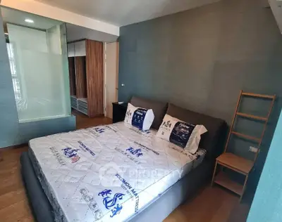 Modern bedroom with stylish decor and ample natural light, featuring a comfortable bed and sleek storage solutions.