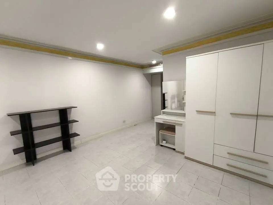 Spacious unfurnished room with modern shelving and wardrobe, ideal for customization.