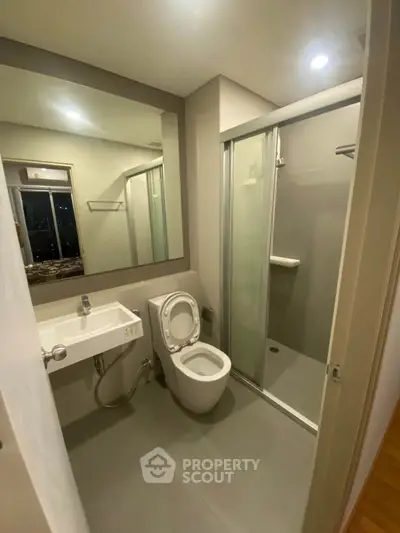 Modern bathroom with sleek shower and minimalist design in urban apartment.