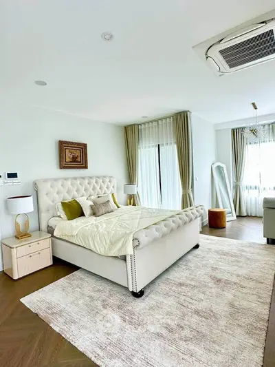 Luxurious bedroom with elegant decor, featuring a plush bed, stylish curtains, and modern air conditioning.