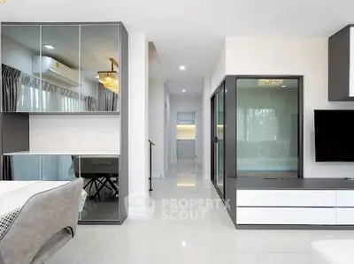 Modern living room with sleek furniture and mirrored cabinets, featuring a stylish open layout.