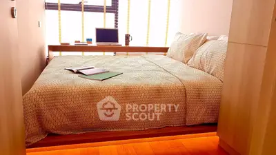Cozy bedroom with natural light and modern decor, featuring a comfortable bed and wooden flooring.