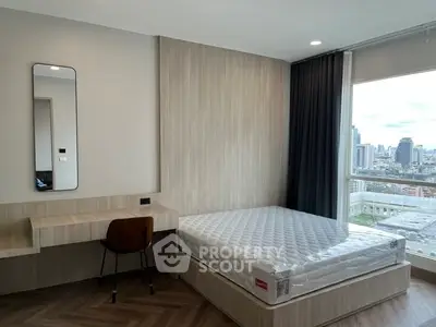 Modern bedroom with city view, featuring a sleek desk and comfortable bed.