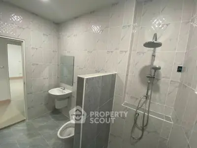 Modern bathroom with sleek shower and tiled walls in a contemporary home.