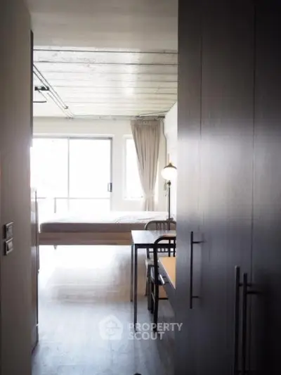 Modern studio apartment with minimalist design and large windows for natural light.