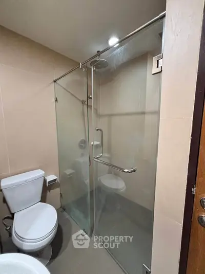 Modern bathroom with glass shower enclosure and sleek fixtures