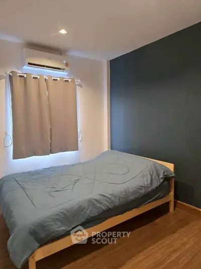 Cozy bedroom with modern decor and air conditioning, perfect for relaxation.