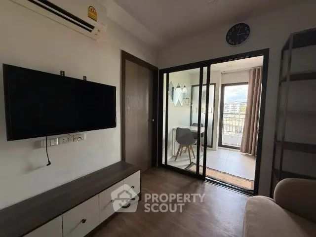 Modern living room with balcony view and sleek furniture in urban apartment.
