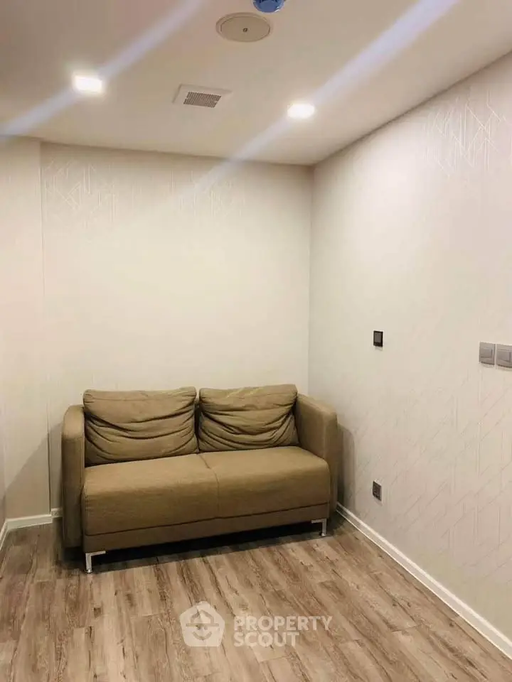 Cozy living room with a comfortable brown sofa and modern lighting, perfect for relaxation.
