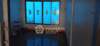 Spacious room with cartoon-themed window decals and polished wooden floor.