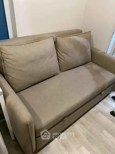 Cozy beige sofa in a modern living room setting, perfect for relaxation and comfort.