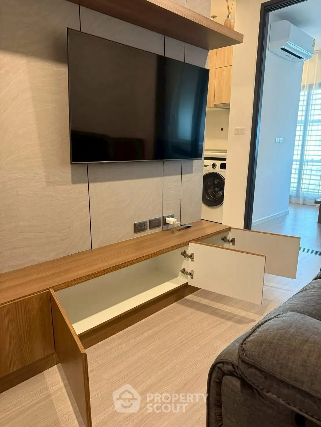 Modern living room with wall-mounted TV and open cabinet storage