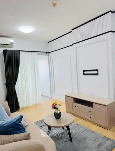 Modern living room with stylish decor and wall-mounted TV bracket, featuring a cozy sofa and elegant curtains.