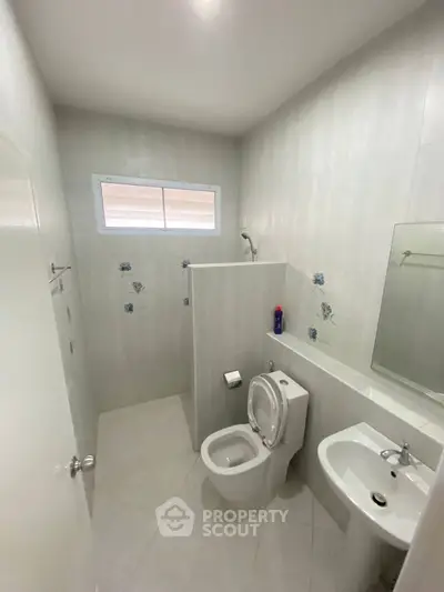 Modern minimalist bathroom with sleek fixtures and natural light.