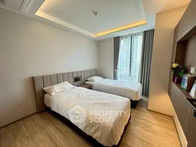 Modern bedroom with twin beds and large window offering city view