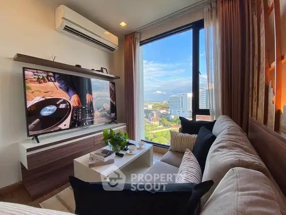 Modern living room with large window offering stunning city view, cozy sofa, and wall-mounted TV.