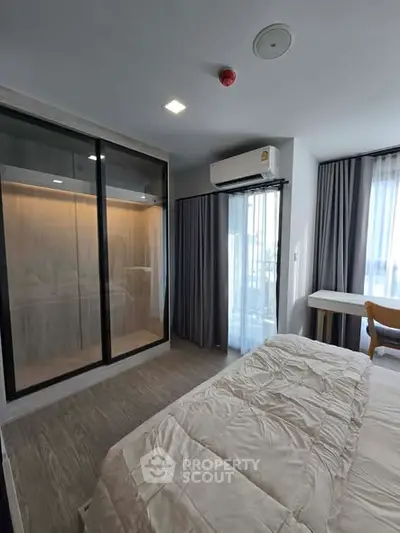 Modern bedroom with large window, built-in wardrobe, and air conditioning.